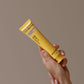 hands holding a natural hydroxyapatite toothpaste yellow tube, brand is About28 Oral Cleanser, mint and bergamot flavour fluoride-free